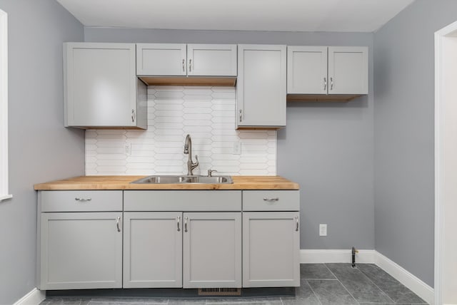 kitchen featuring sink, white cabinets, and wooden counters