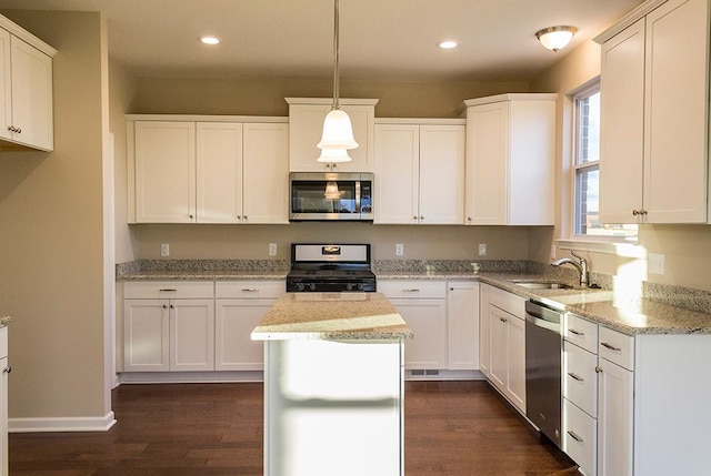 kitchen with sink, white cabinetry, hanging light fixtures, and appliances with stainless steel finishes