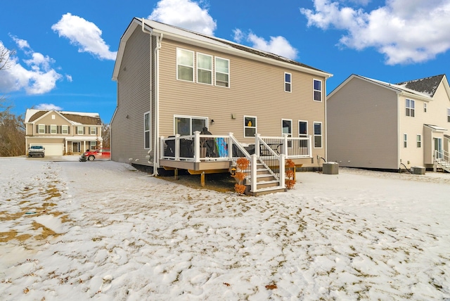 snow covered property with cooling unit and a deck