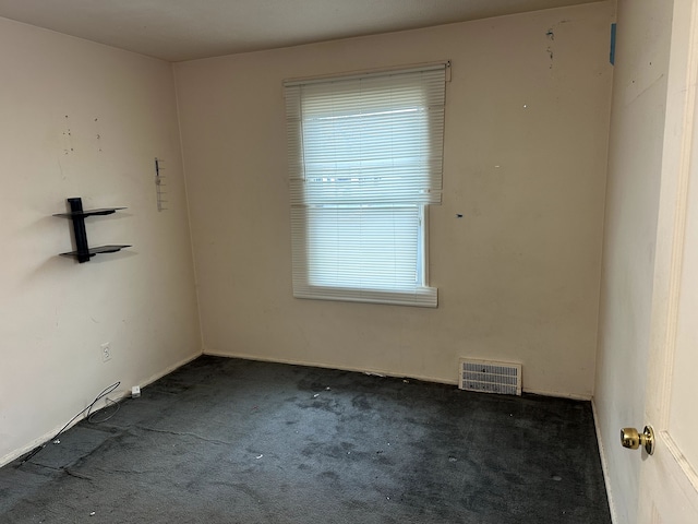 unfurnished room featuring dark carpet