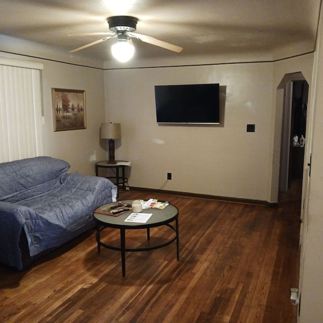 living room featuring ceiling fan and dark wood-type flooring