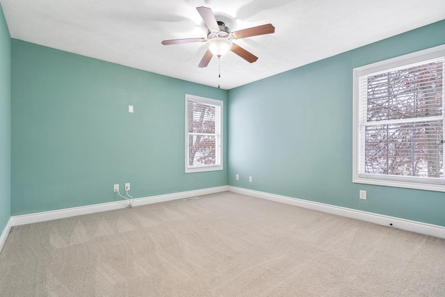 carpeted spare room featuring ceiling fan