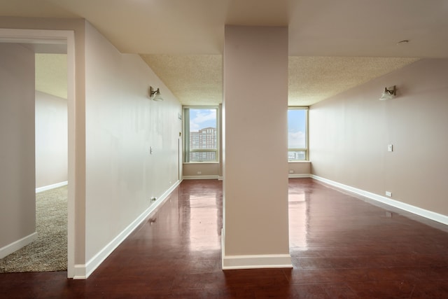 corridor featuring dark hardwood / wood-style flooring and a textured ceiling