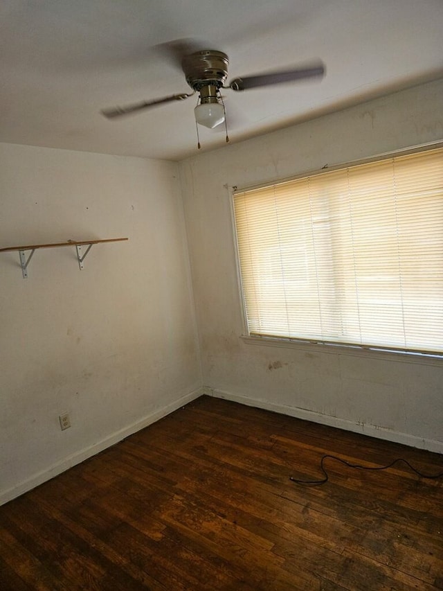 empty room with ceiling fan and dark wood-type flooring