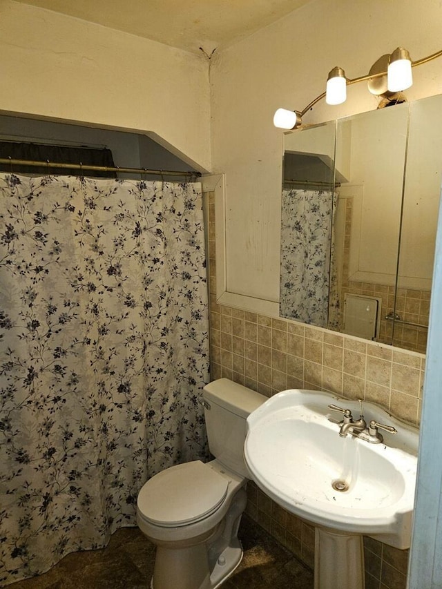 bathroom with toilet, walk in shower, tile walls, decorative backsplash, and sink