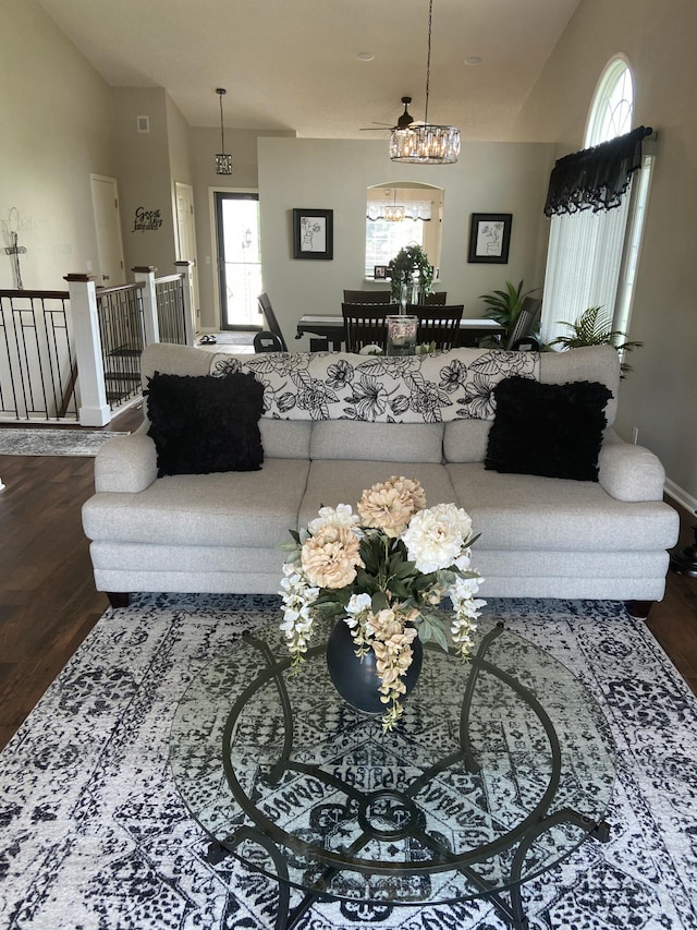 living room featuring dark hardwood / wood-style flooring, a healthy amount of sunlight, and a notable chandelier