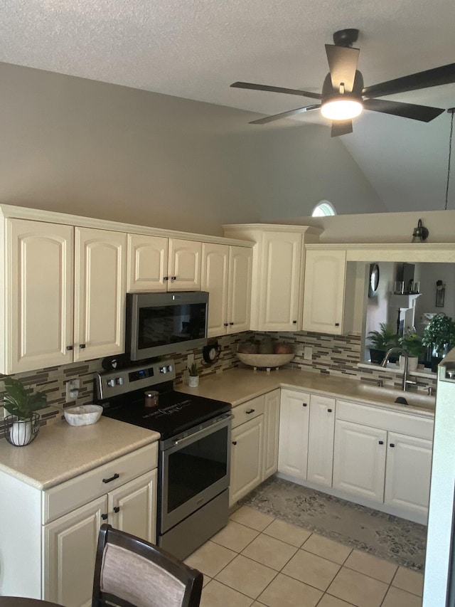 kitchen with backsplash, white cabinetry, sink, and stainless steel appliances