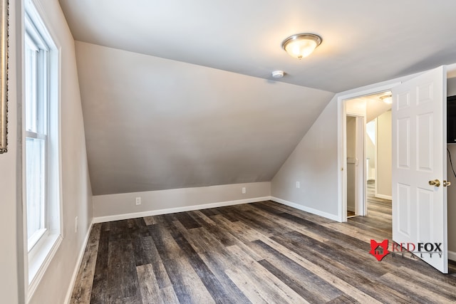 additional living space with dark hardwood / wood-style flooring and vaulted ceiling