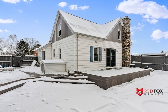 view of snow covered rear of property