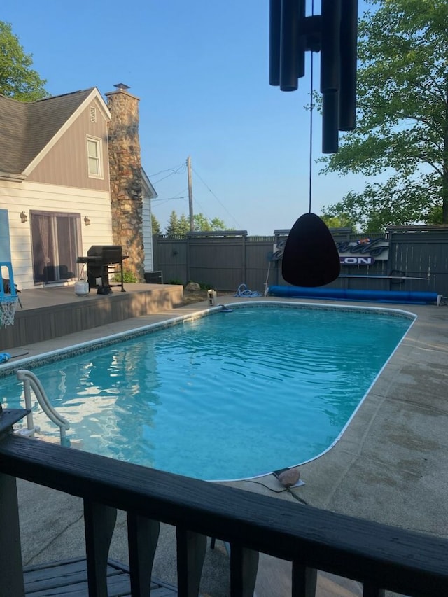 view of swimming pool featuring area for grilling and a patio area