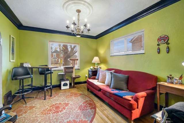 living room featuring a chandelier, a textured ceiling, light hardwood / wood-style flooring, and crown molding