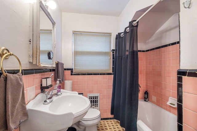 full bathroom with shower / bath combo, toilet, tile walls, and sink