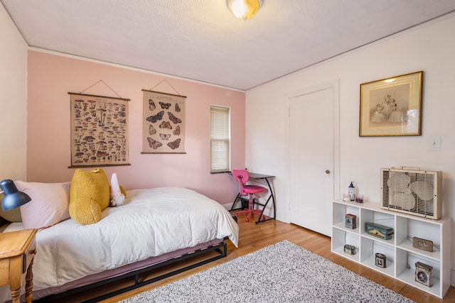 bedroom with hardwood / wood-style floors and ornamental molding