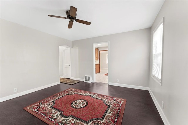 bedroom featuring connected bathroom, ceiling fan, and dark wood-type flooring