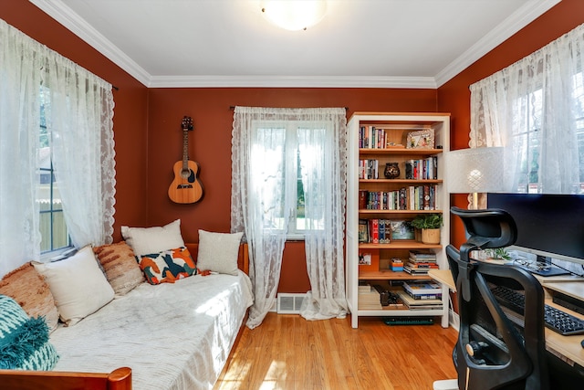 office area with light hardwood / wood-style floors and ornamental molding