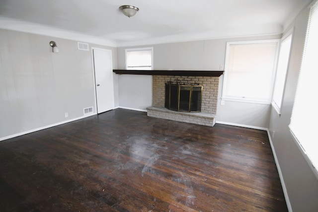 unfurnished living room with dark hardwood / wood-style floors and a brick fireplace