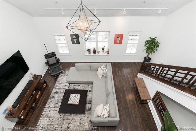 living room featuring dark hardwood / wood-style floors, an inviting chandelier, and track lighting