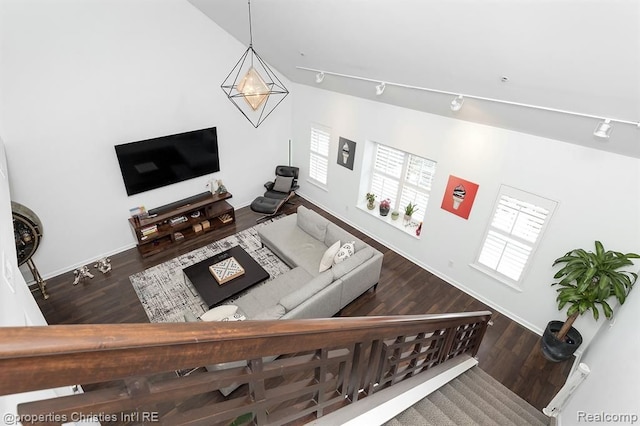 living room featuring wood-type flooring, track lighting, and vaulted ceiling