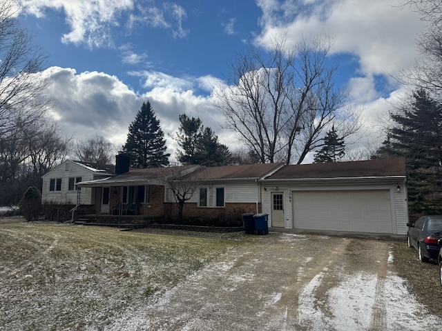 view of front of home with dirt driveway, brick siding, a chimney, and a garage