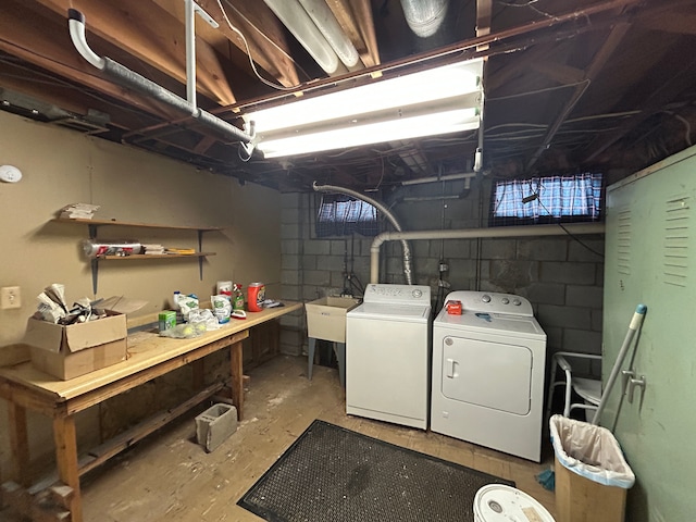 unfinished below grade area with washing machine and dryer and a sink