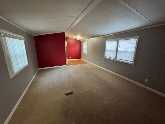 spare room featuring ornamental molding, lofted ceiling, and carpet