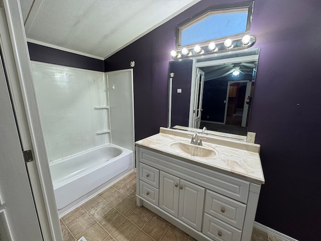 bathroom with vanity, tub / shower combination, vaulted ceiling, and a textured ceiling