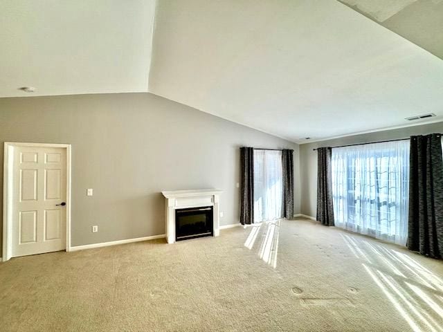 unfurnished living room with light colored carpet and vaulted ceiling