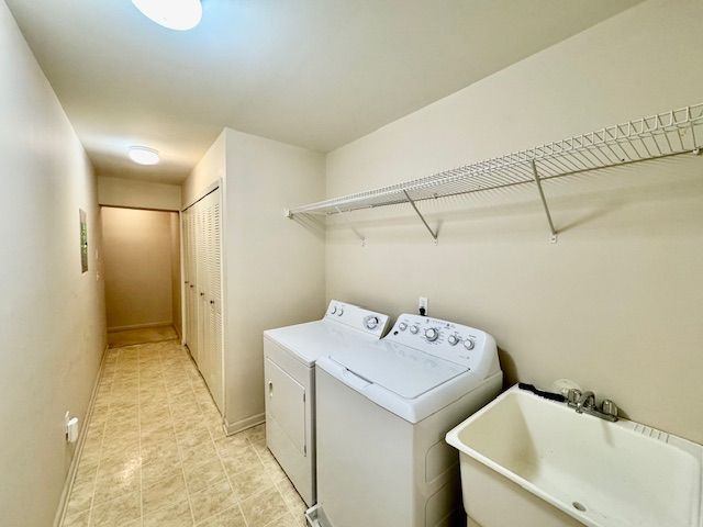 clothes washing area featuring sink and washer and dryer