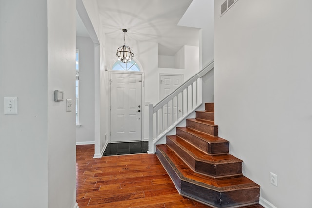 entryway featuring dark hardwood / wood-style flooring and a notable chandelier