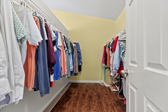 walk in closet featuring wood-type flooring and vaulted ceiling