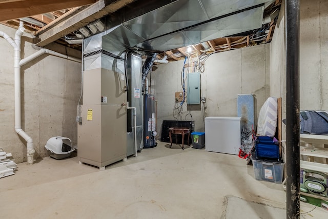 basement with electric panel, water heater, heating unit, and fridge