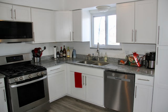 kitchen featuring stone counters, white cabinetry, appliances with stainless steel finishes, and sink