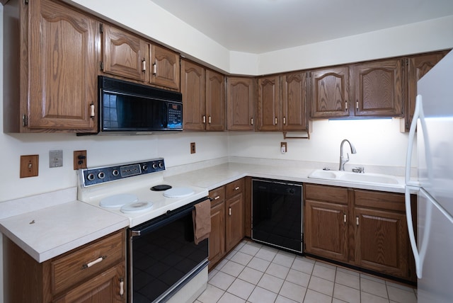 kitchen with light tile patterned flooring, sink, and black appliances