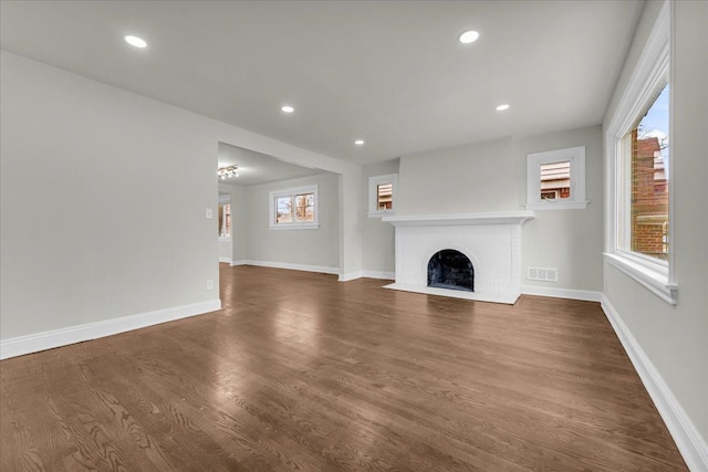 unfurnished living room with a fireplace and dark wood-type flooring