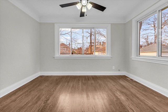 unfurnished room with hardwood / wood-style floors, ornamental molding, ceiling fan, and a healthy amount of sunlight