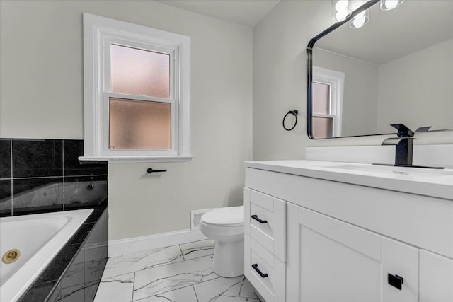 bathroom with vanity, plenty of natural light, and tiled tub