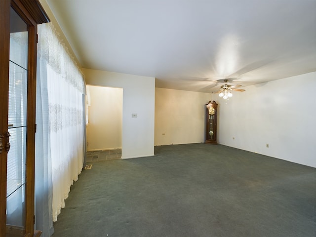 empty room with dark carpet and ceiling fan