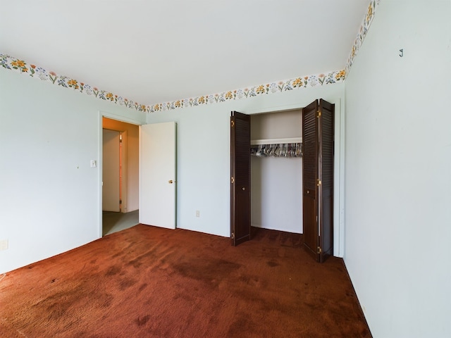 unfurnished bedroom featuring dark colored carpet and a closet