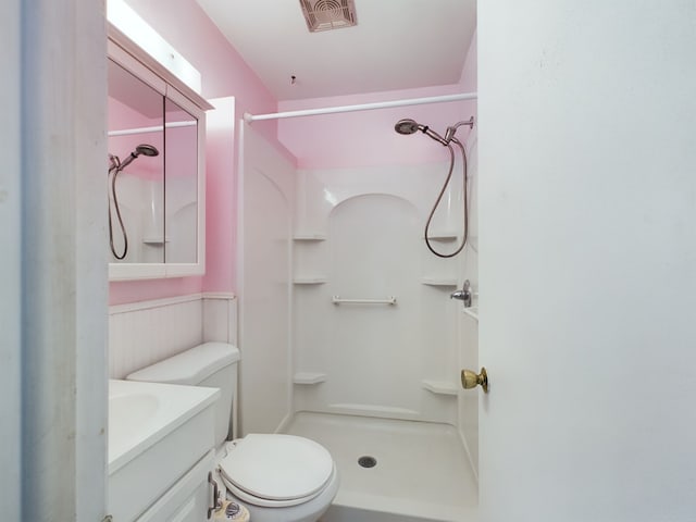 bathroom with a shower, vanity, and toilet