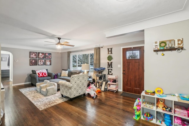 living room with arched walkways, ceiling fan, a wealth of natural light, and wood finished floors