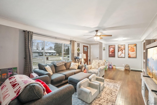 living room featuring ceiling fan, ornamental molding, and light wood-type flooring