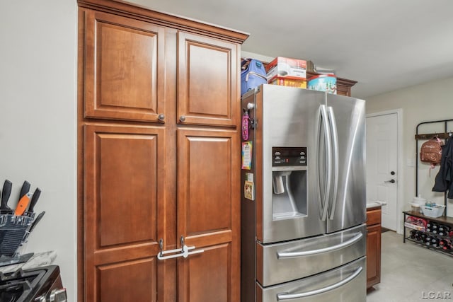 kitchen with stainless steel refrigerator with ice dispenser and brown cabinetry
