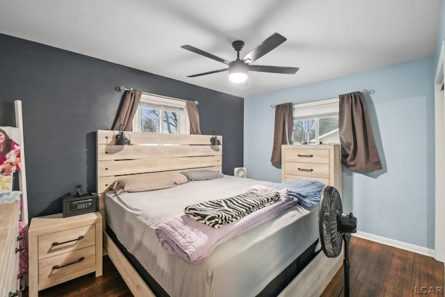 bedroom featuring multiple windows, dark hardwood / wood-style flooring, and ceiling fan