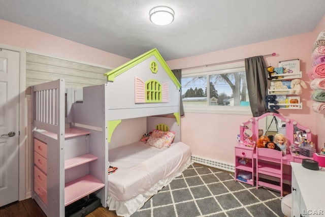 bedroom with wood finished floors and baseboard heating
