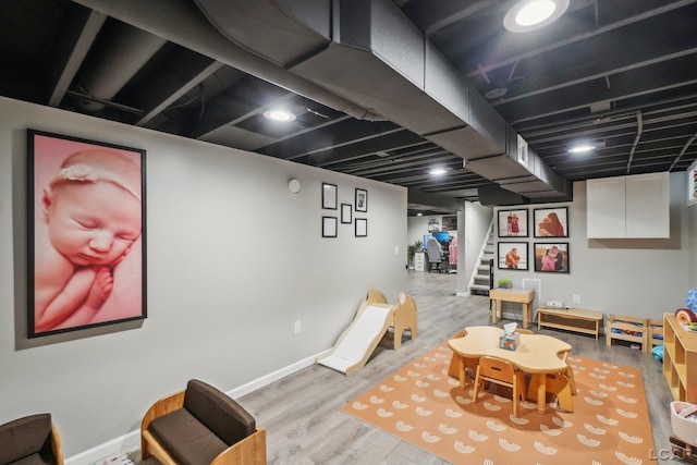 game room with baseboards and wood finished floors
