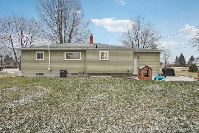 rear view of house featuring a lawn and central AC unit