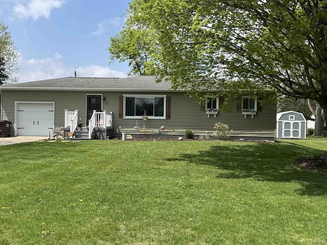 ranch-style home with a front yard, a shed, concrete driveway, an attached garage, and an outbuilding