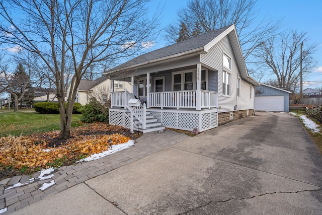 view of front of property with an outbuilding, a front yard, a porch, and a garage