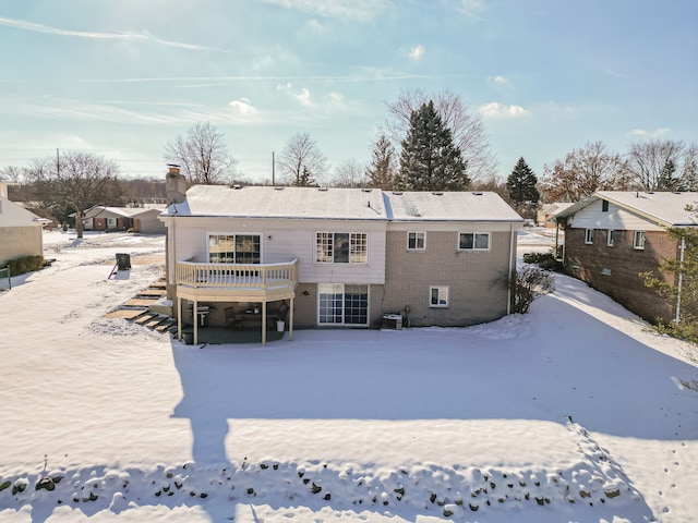 snow covered house featuring a wooden deck