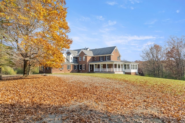 view of front of home with a front lawn and a sunroom